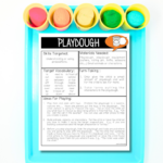 A teal coloured tray with five different colours of play dough at the top with a play dough handout out